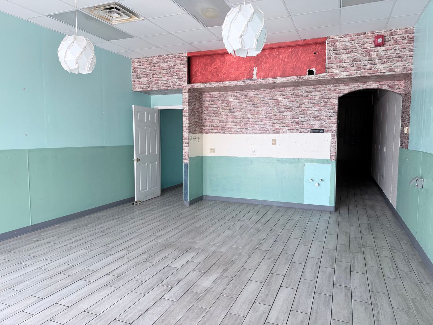 Vacant suite, brick arch and pendant lights